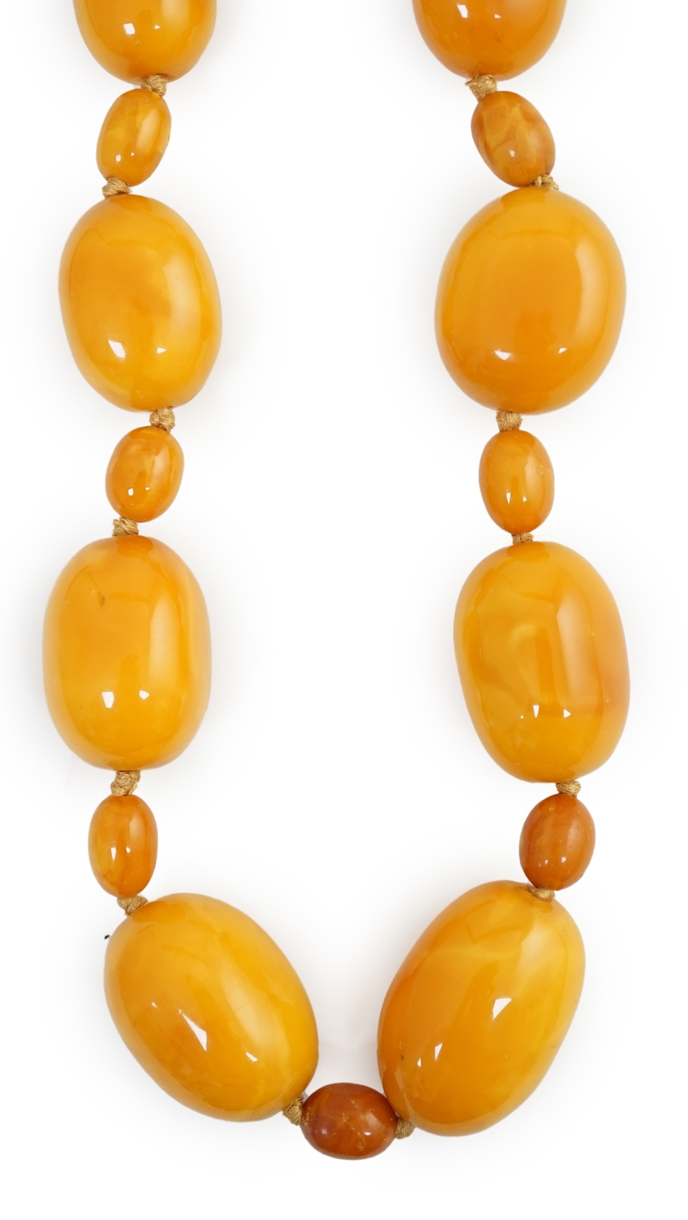 A single strand graduated oval amber bead necklace, with small amber bead spacers